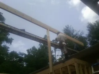 Carpenter setting a ridge beam over a new addition frame — Ice Dam Removal by Roofing Brothers in Wilkeson