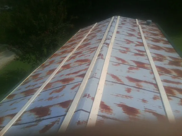 Rusted metal roof panels with new wood purlins before replacement — Storm Damage Roof Repair in Wilkeson by Roofing Brothers
