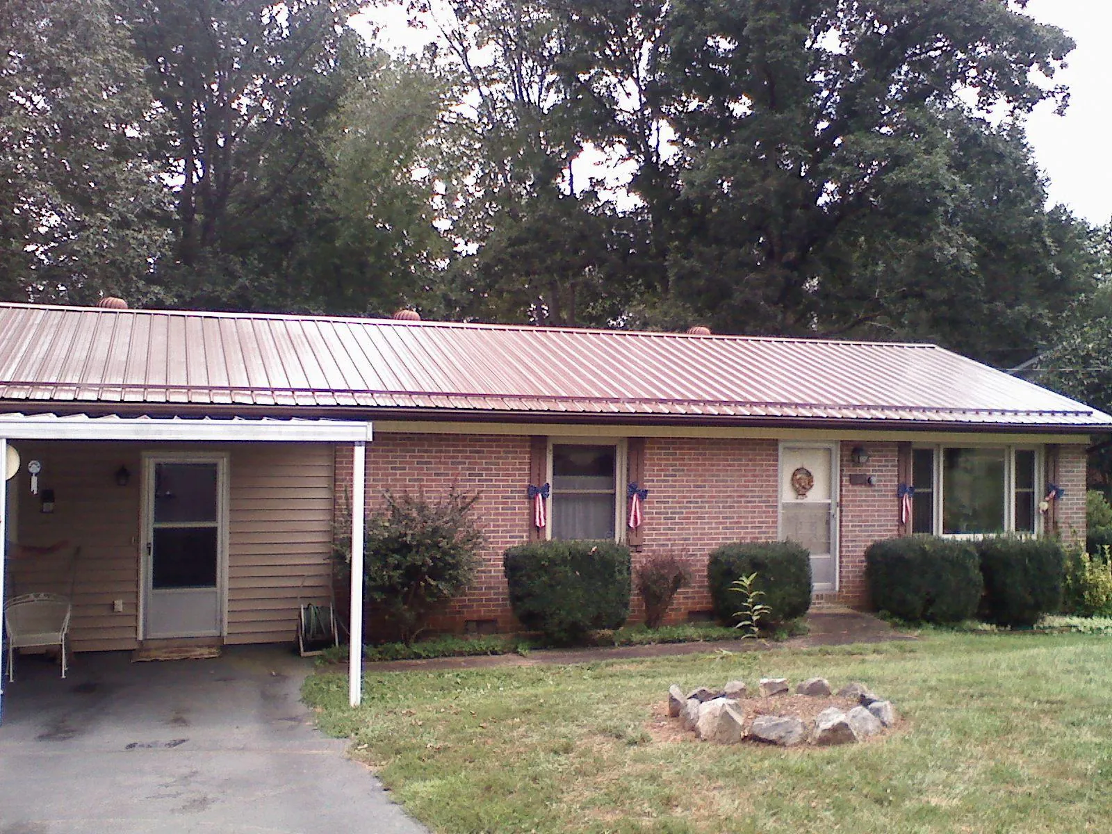 Bronze metal roof and carport on a brick ranch home — Roof Repair work by our crew in Wilkeson
